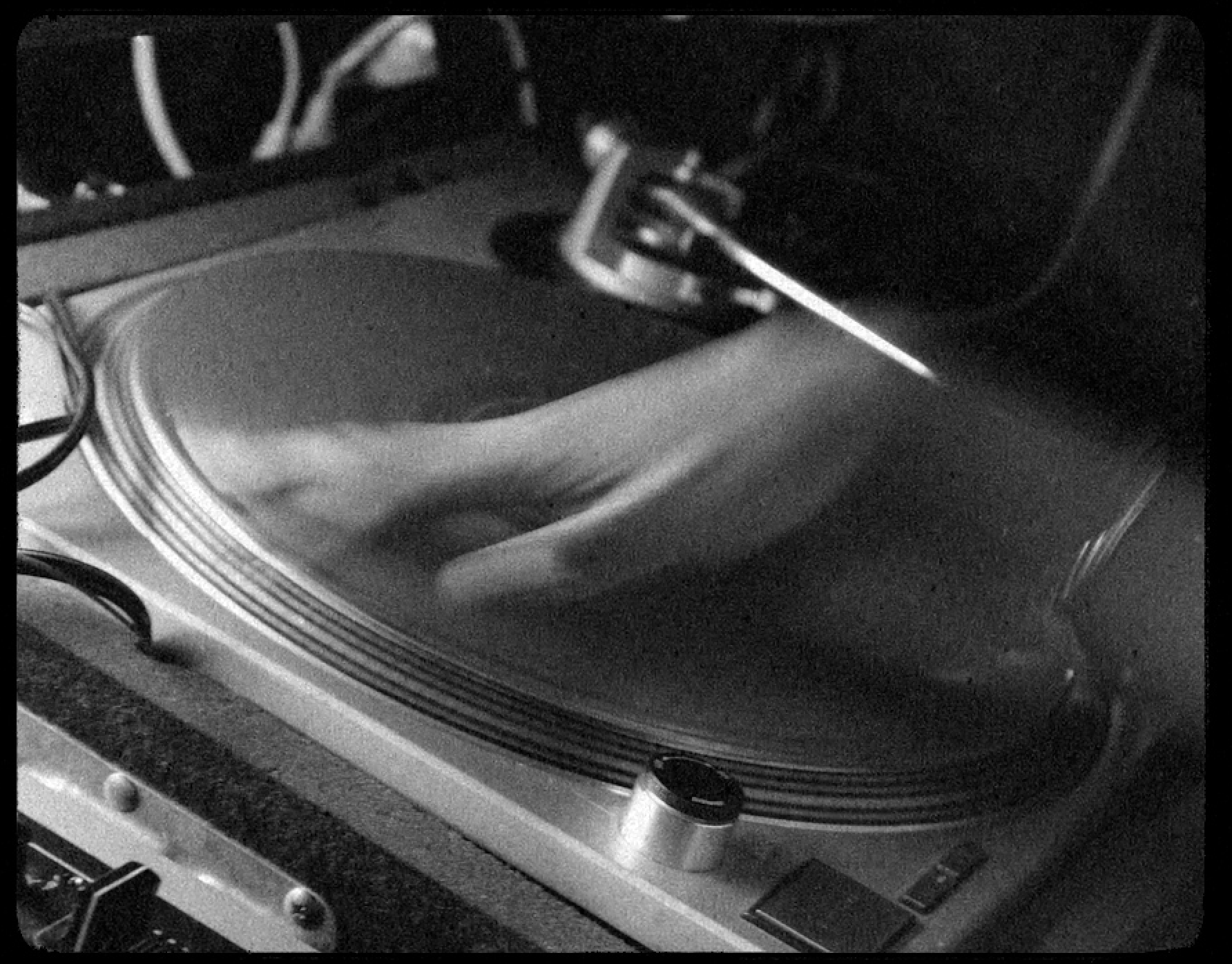 A blurry hand on a turn table, photo in black and white