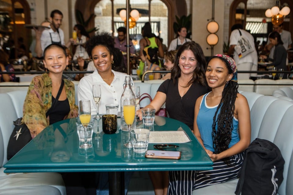 A photo of four filmmakers sitting at a restaurant table for the Director's Brunch. They are smiling at the camera. Sponsorship BlackStar Film Festival 2022.
