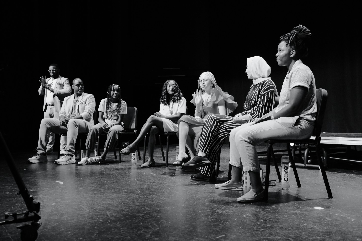 A black-and-white photo of six people sitting on stage for the Childhood on Screen panel.