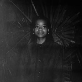 A photograph shows a portrait of Crystal Kayiza.