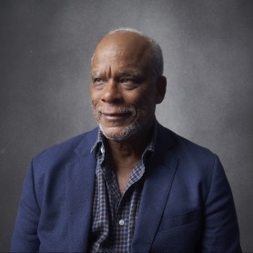 A photograph shows a portrait of Stanley Nelson.