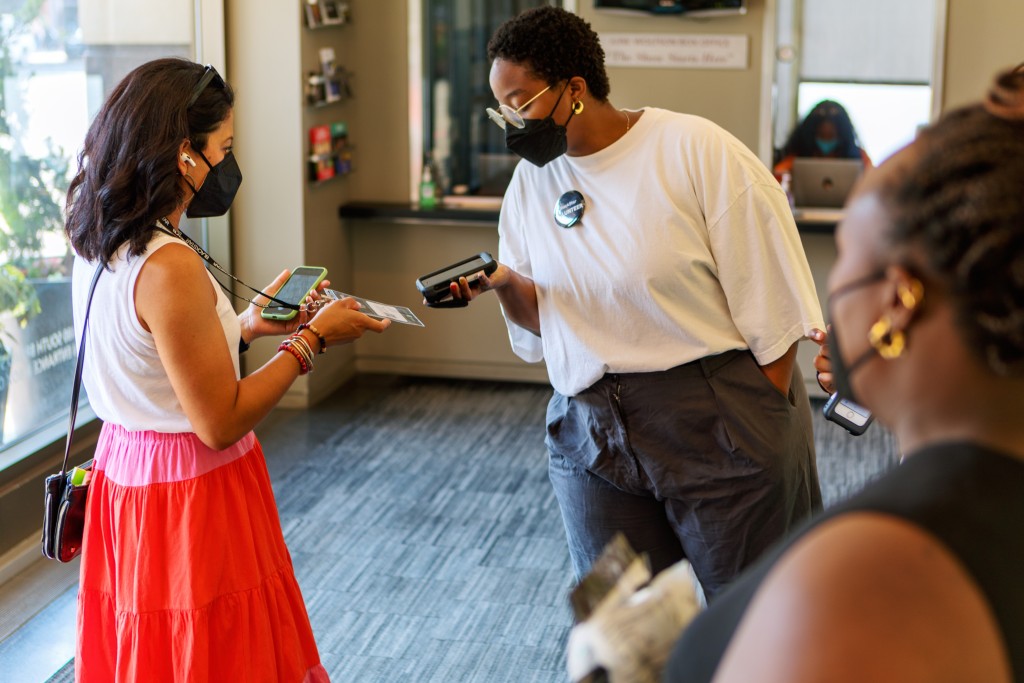 A photo of a ticket holder and ticket taker at the BlackStar Film Festival.