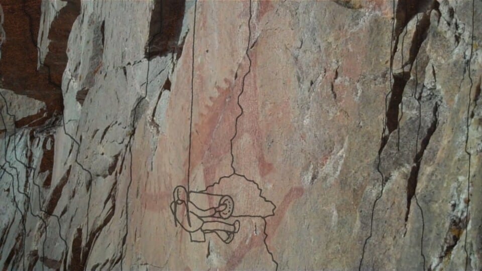 A line drawing from “INAATE/SE/ of a little man climbing up a mountain.