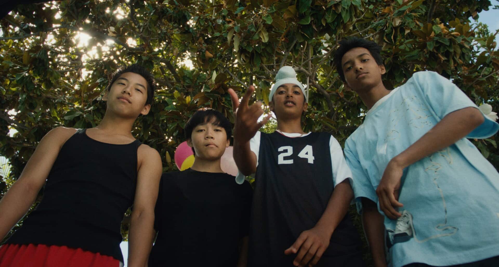 A low angle shot of four Asian and South Asian tween boys in “Didi” (2024). They’re staring directly into the camera.