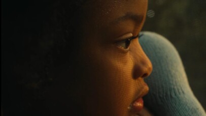 A close up on Miwo (5) holding a stuffed animal and looking out the window after his sister.