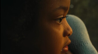 A close up on Miwo (5) holding a stuffed animal and looking out the window after his sister.