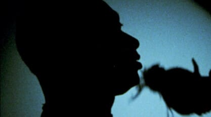 Blue backlit image of a Black male silhouette on the dance floor.