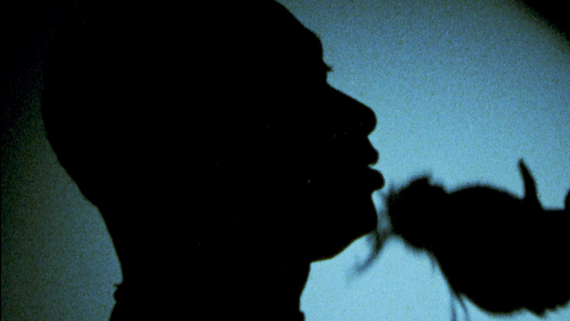 Blue backlit image of a Black male silhouette on the dance floor.