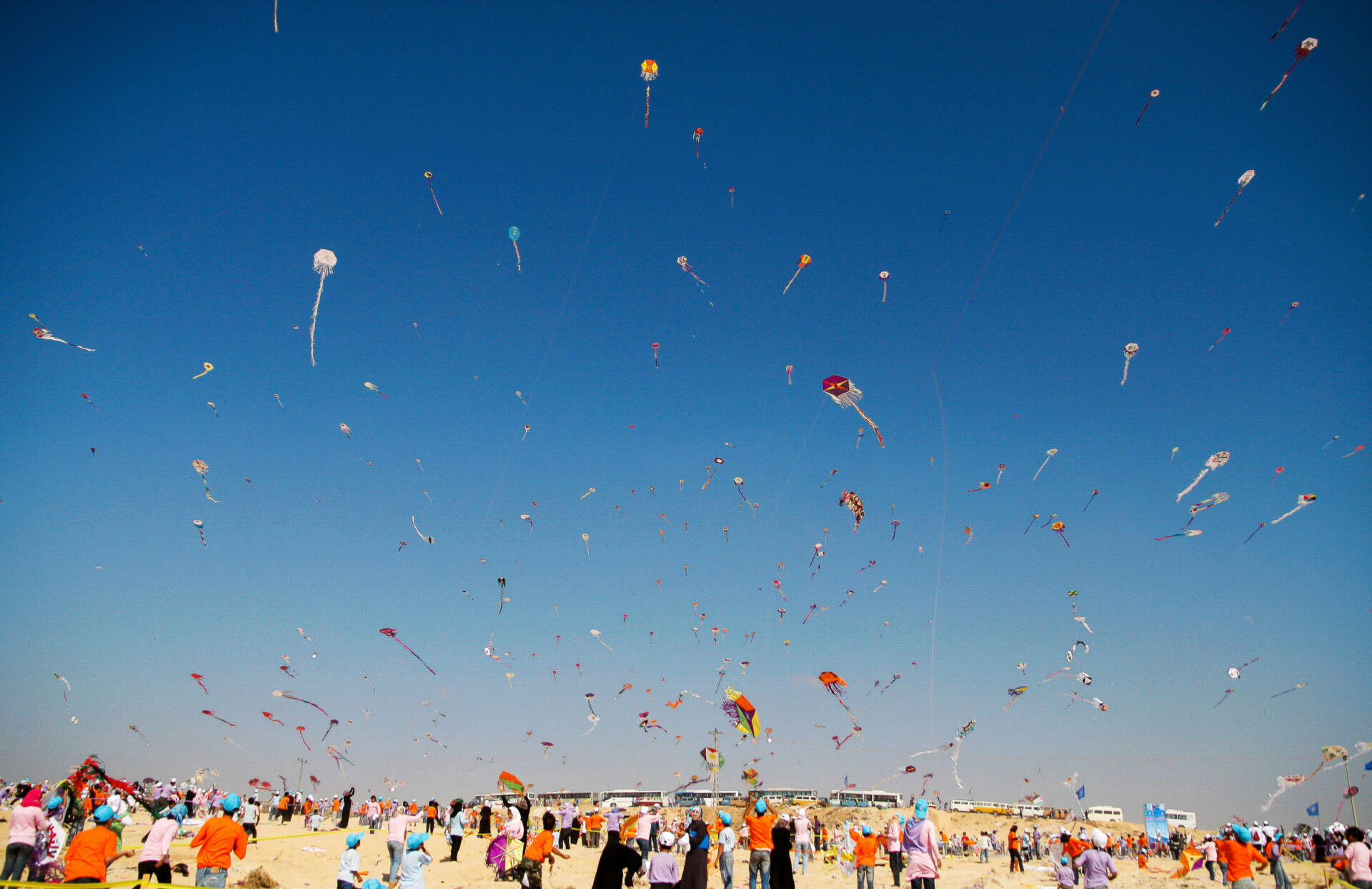 A massive gathering of Palestinian children and young people fly colorful kites in Gaza.