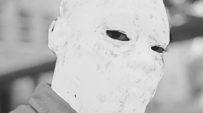 A still from the film Nickel Boys (2024). A black and white close-up of a person with only his eyes visible, his face is whited out.