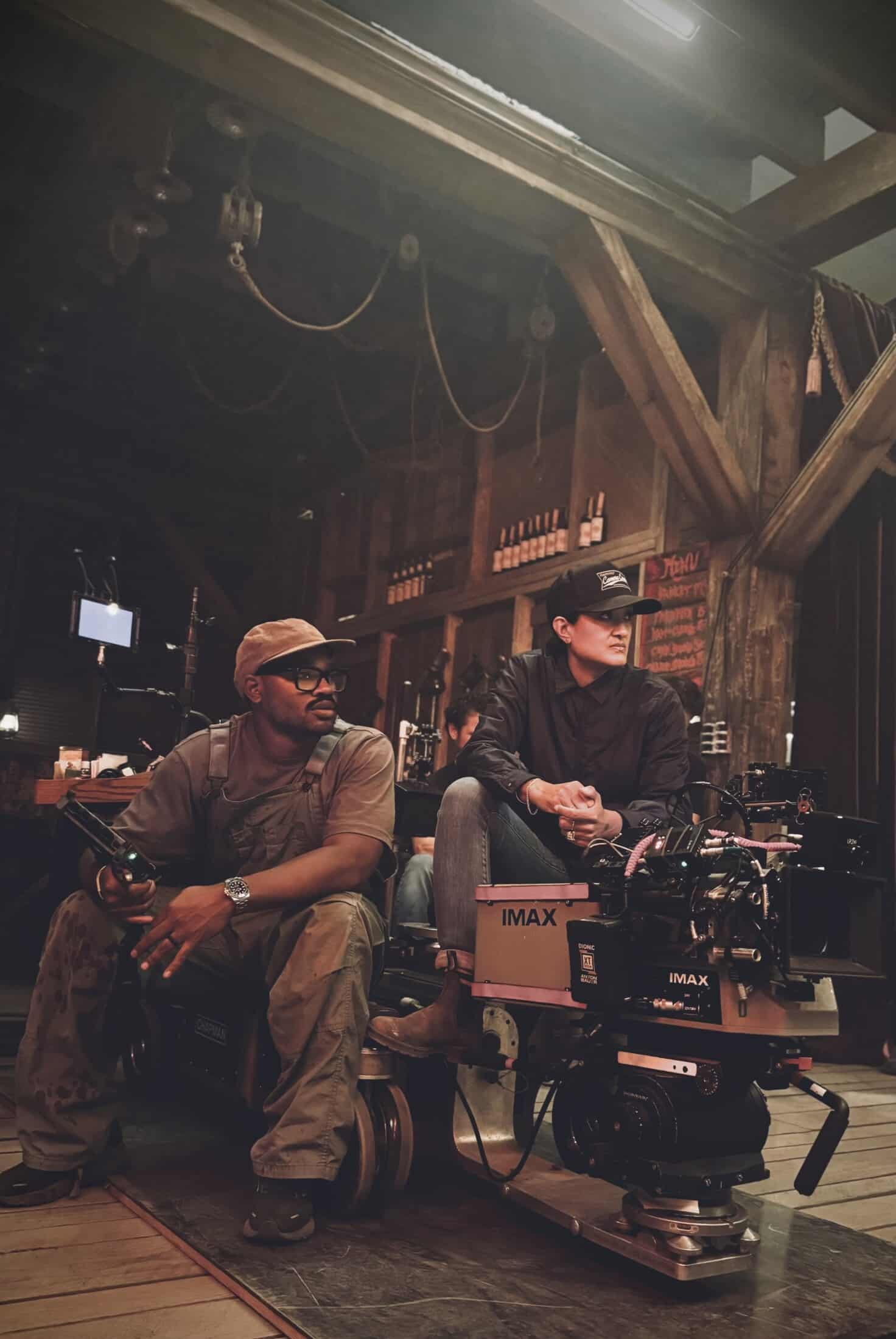 A photograph from the set of Sinners (2025). Autumn Durald Arkapaw sits near a film camera and the director, Ryan Coogler sits next to her.
