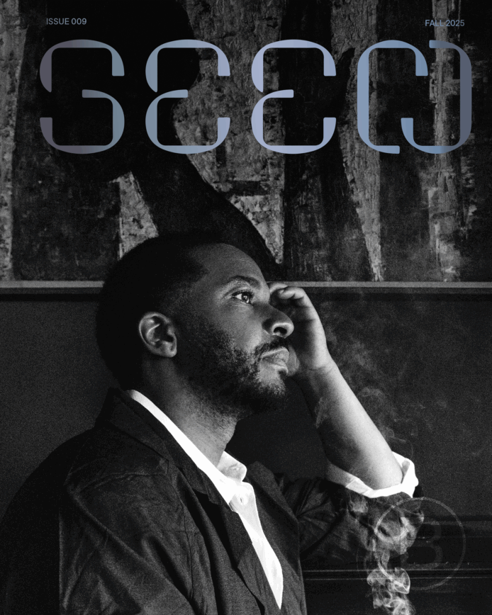 A picture of André Holland, in profile, looking to the right with his left hand on his head. Overlaid on top is the “Seen” logo. The BlackStar “B” logo is embossed in the bottom right corner with smoke overlaying it.