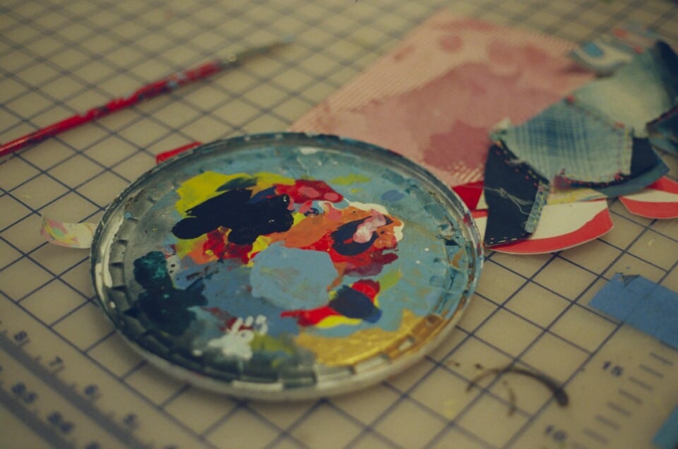 The lid of a plastic bucket that’s used as a paint palette.