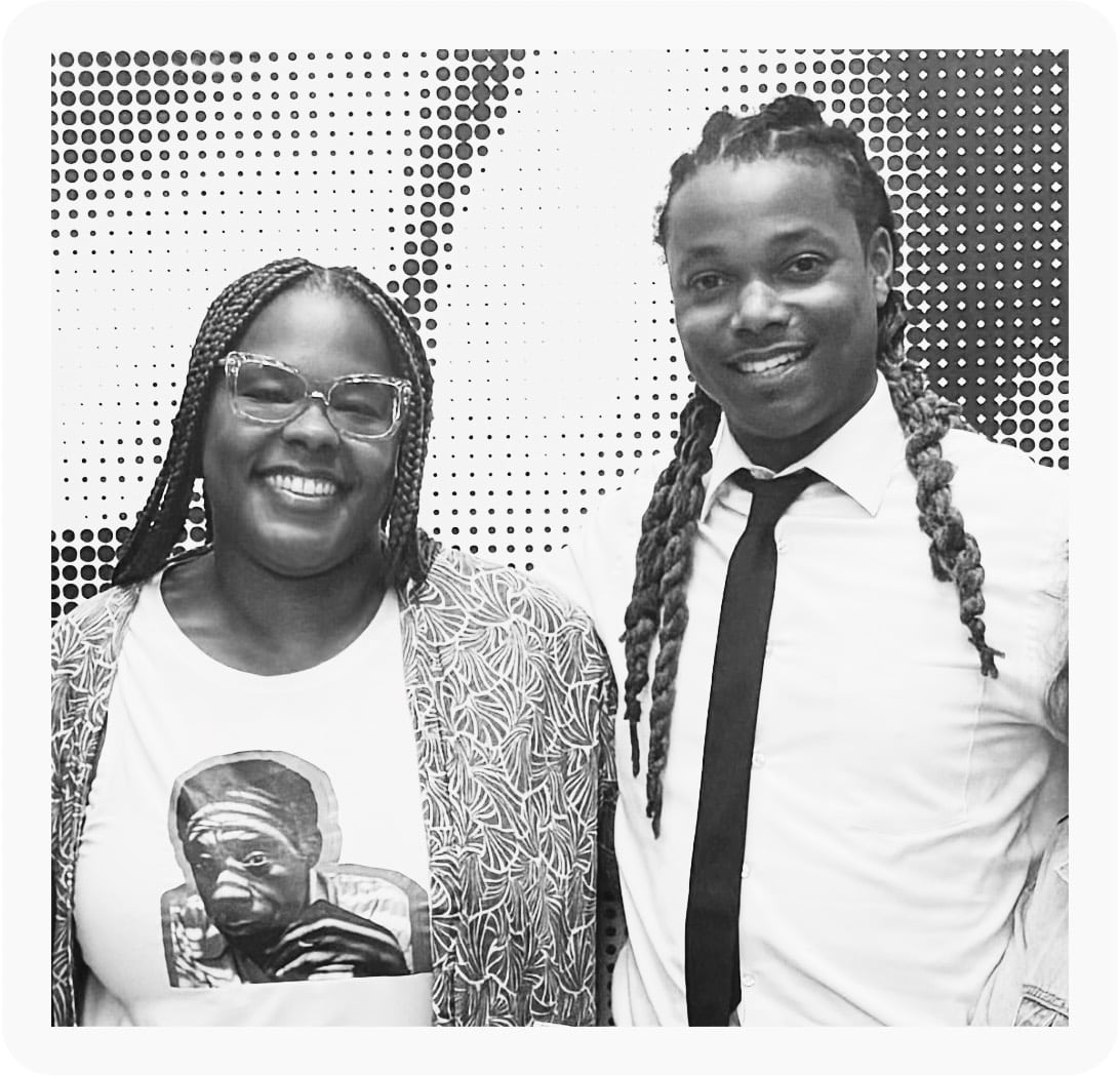 A black-and-white photo of Beandrea July and Kendale Winbush standing arm-in-arm. Beandrea is wearing a t-shirt with an image of James Baldwin.