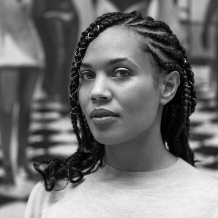 A black-and-white headshot of Onye Anyanwu, she is Black woman. She has braids. She is looking softy at the camera.
