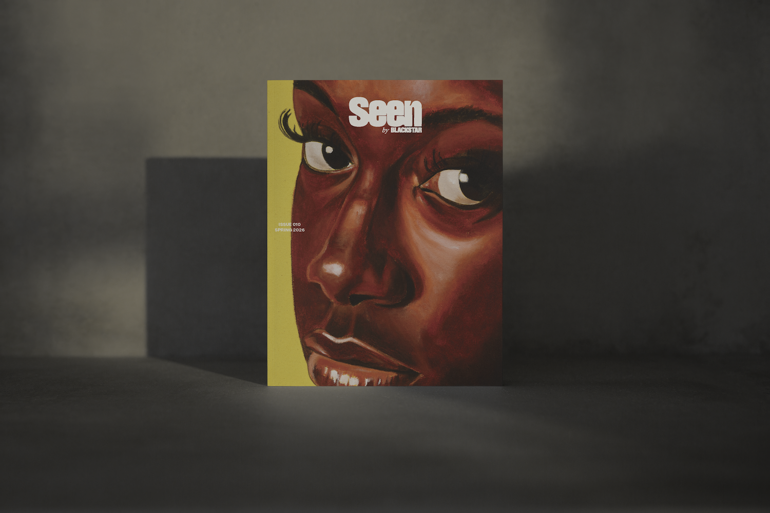 A mock-up of the Seen 010 cover on a black and tan background. The cover image is a reimagined painting of the Girl with a Pearl Earring featuring a Black girl looking directly at the camera with a strong gaze. She has long, detailed eyelashes, and her expression is calm but intense. Overlaid on top is the “Seen” logo.