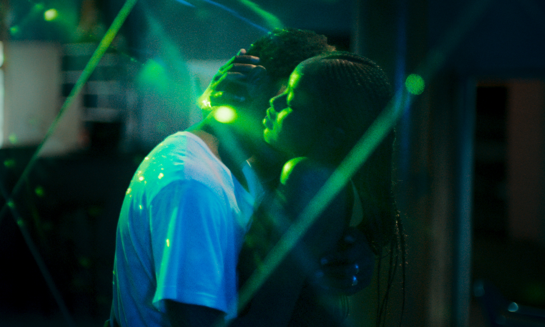 Still from the film Atlantics shows two people embracing in a dark nightclub.