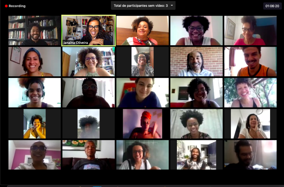 A grid featuring twenty five people on a Zoom video call smile and look at their cameras during a discussion.