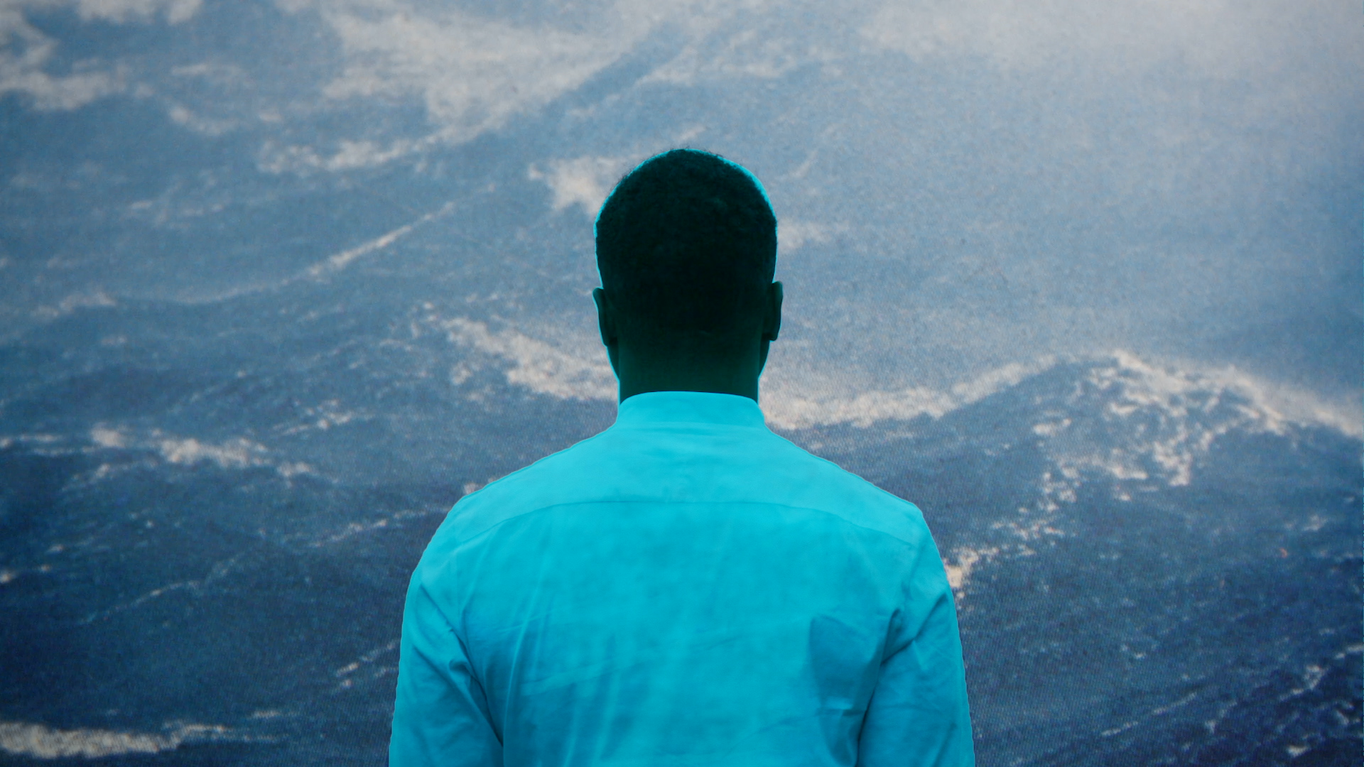 A still from After Sherman shows a Black person, their back to the camera, looking out at an expansive mountain range.