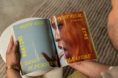 A photo of Seen Issue 004 opened to an interior spread, featuring an article about the filmmaker Martine Syms. The magazine is seen from above, held in a person's lap.