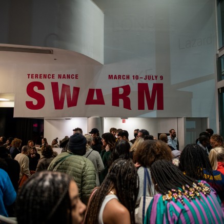 A photo shows a crowd gathering indoors at night, under a large wall text that reads "Terence Nance: Swarm March 10-July 9".