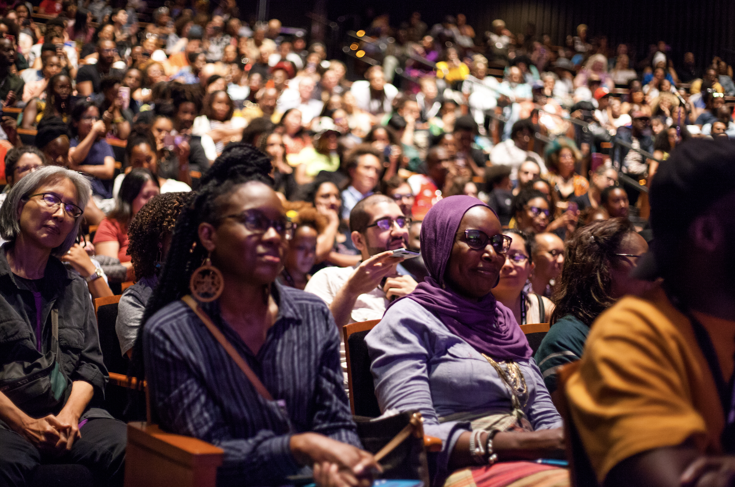 A photo of a crowd at BlackStar Film Festival. The theater is packed with Black and Brown individuals.